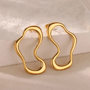 Polished 18k gold irregular wavy hoop earrings displayed on a minimalist stone pedestal