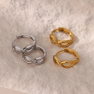 Boucles d'oreilles créoles infini minimalistes en or et argent sur fond pierre
