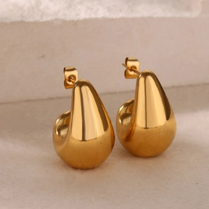 Close-up of chunky water drop earrings with polished 18k gold plating on stone base