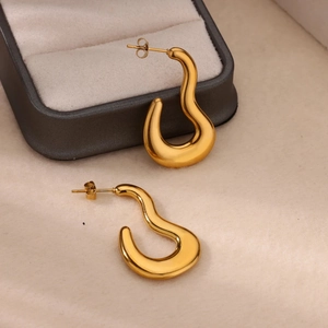 Detailed macro view of 18k gold-plated irregular wave-shaped U-shaped earrings on jewelry box