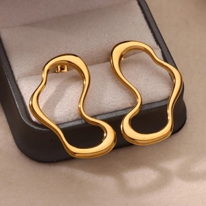 Detailed shot of irregular wavy gold stud earrings presented in a luxury jewelry gift box