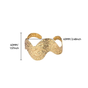Macro detail of 40mm wide gold plated hammered cuff bracelet with textured wave edges