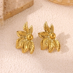 Detailed macro view of 18k gold leaf-shaped stud earrings with realistic textures