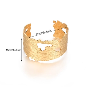 Vue détaillée d'un large bracelet manchette plaqué or 18 carats avec texture martelée et découpes