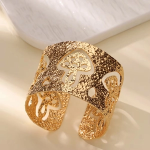 Close-up of hammered 18K gold-plated wide cuff with hollow mushroom cutout design