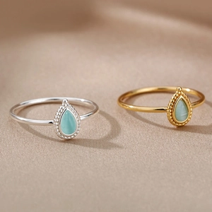 Detail view of oval semi-precious stone rings in gold and silver stainless steel finishes