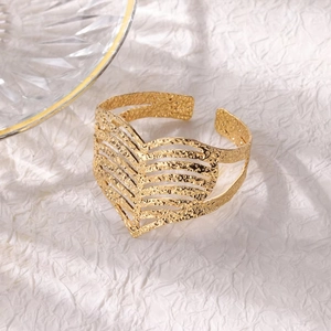 Close-up of golden hammered texture heart-shaped hollow opening cuff bracelet