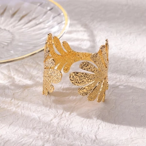 Detailed close-up of 18K gold-plated wide open cuff with hammered leaf pattern texture