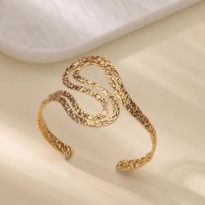 Detail view of 18K gold plated stainless steel cuff bracelet with irregular hammered texture