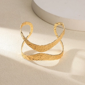 Détail macro du bracelet jonc doré martelé avec motif de vagues sculptées élégant
