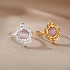 Detail of bohemian gold and silver oval stone rings with intricate beaded metal edges