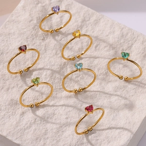 Detail view of multicolored heart-shaped zircon stones on gold adjustable rings