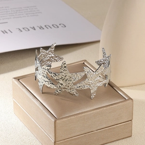 Détail du bracelet ouvert étoile de mer argentée avec texture martelée sur boîte à bijoux