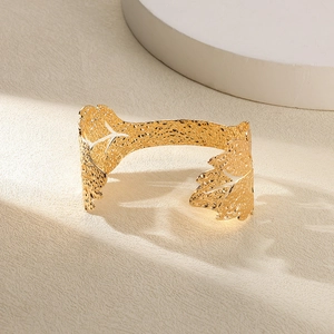 Vue détaillée d'un bracelet doré texturé avec un effet de finition martelé artistique
