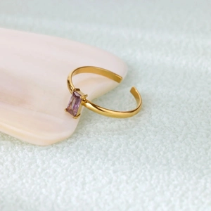 Detail of adjustable gold ring with a rectangle purple gemstone in a four-prong setting