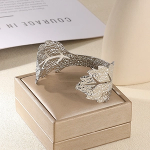 Détail du bracelet manchette large argenté martelé avec bordure en forme de feuille évidée