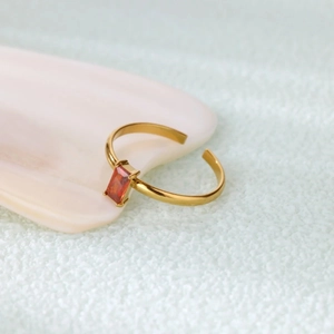 Detailed side view of gold-plated adjustable ring with rectangle orange-red zircon stone