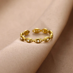 Bague ouverte dorée minimaliste œil maléfique avec zircons sur tissu beige doux