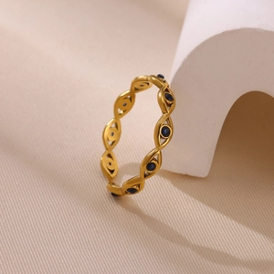 Détail d'une bague Evil Eye dorée avec zircons bleus et design ajouré élégant
