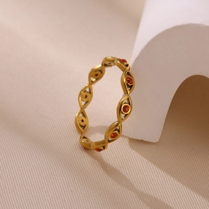 Détails macro de la bague œil protecteur dorée ornée de zircons cubiques rouges circulaires