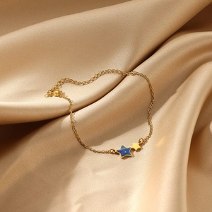 Detailweergave van de 18k vergulde roestvrijstalen armband met sterren op zijden achtergrond