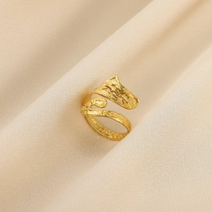 Nahaufnahme des goldenen verstellbaren Rings mit Hammerschlag-Textur auf beiger Seide