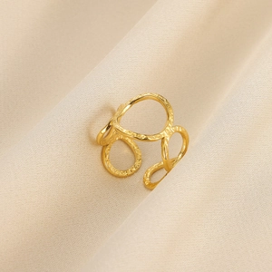 Detail eines vergoldeten Edelstahlrings mit unregelmäßigem, hohlgeometrischem Design