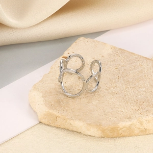 Detail von silbernen geometrischen Ringen mit Hammerschlag-Finish auf Steinfläche