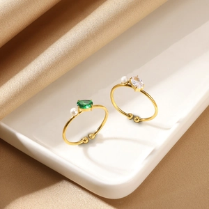 Elegant gold adjustable rings with green gemstone and white pearls on silk