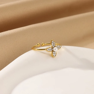 Detailed macro view of gold-plated flower ring with zircon stones and a central pearl