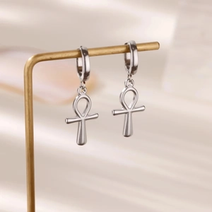 Detailansicht silberner Titanstahl-Ankh-Kreuz-Ohrringe, hängend an einem Metalldisplay