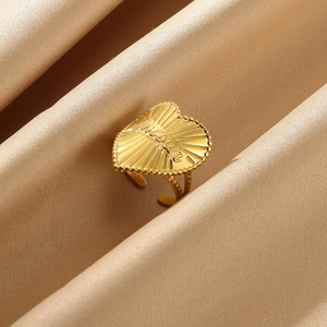 Detailed view of a gold heart ring with Amour engraving on elegant champagne satin