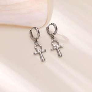 Makro-Detail des silbernen Ankh-Kreuz-Anhängers an einem Edelstahl-Ohrring