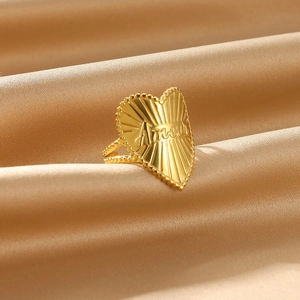 Detailed macro view of golden heart ring with Amour engraving and radial texture details