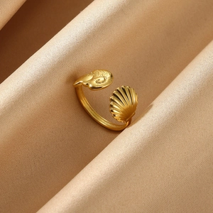 Detail of adjustable gold ring featuring shell and snail motifs on satin fabric