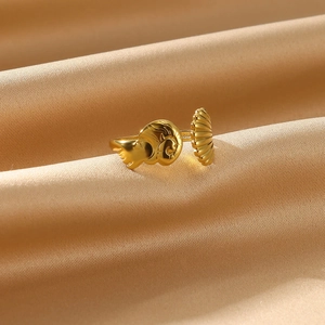 Macro detail of golden open ring featuring artistic snail and shell textures on silk