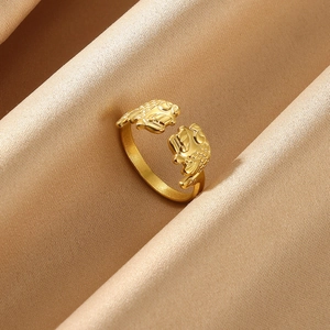 Detail of golden open ring featuring dual koi fish carvings on luxury silk fabric