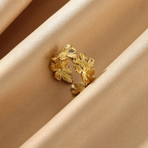 Macro view of gold flower daisy ring on elegant champagne silk fabric background