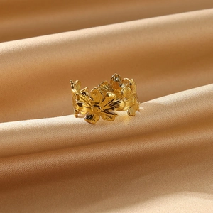 Close-up of golden stainless steel flower ring featuring a row of daisy floral patterns