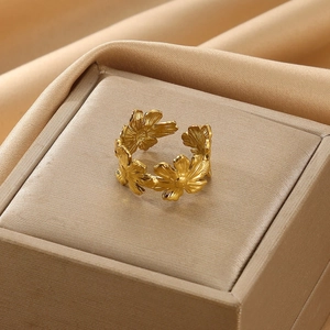 Macro detail of golden daisy floral open ring with brushed metal texture petals