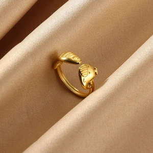 Macro detail of golden open ring with wave texture on champagne silk background