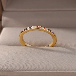Adjustable golden ring featuring colorful round-cut cubic zirconia in a plush velvet box