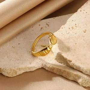 Detailed macro view of golden hug hands ring with pearl on stone and silk background