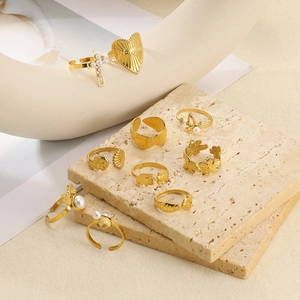 Golden stackable ring set with pearl cross, butterfly and Amour heart engraved details