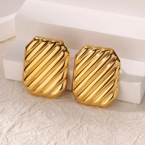 Detailed macro view of gold-plated geometric earrings with elegant diagonal striped texture