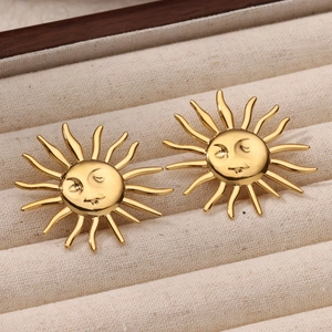 Close-up of gold sun-shaped stud earrings with facial expressions in a jewelry box
