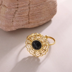 Close-up of vintage gold open ring featuring a black stone with white veins and floral detail