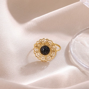 Macro shot of 18K gold bow ring featuring vintage filigree flower and black marble stone
