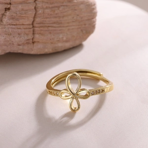 Macro detail of gold-plated clover ring featuring cubic zirconia accents and floral design
