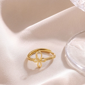 Close-up of gold plated bow ring featuring zircon inlay on silk background